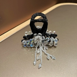 Detail of luxury hair claw featuring crystal floral clusters and elegant bead tassels