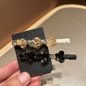 Close-up of luxury beaded crystal hair clips with champagne and black faceted stones