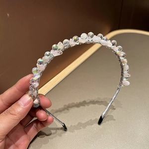 Detail of beaded headband featuring pink raw stones and shimmering crystal beads