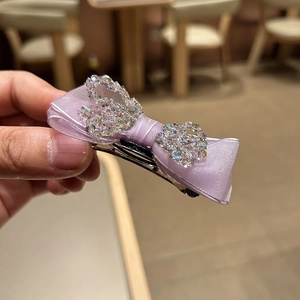 Detail of lavender silk bow hair claw with sparkling rhinestones and silver metal clip