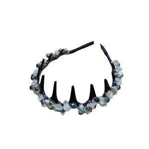 Handmade headband with blue crystals and woven stones on a black toothed frame