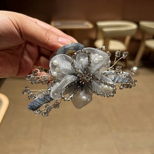 Dettaglio della pinza per capelli a fiore in organza fatta a mano con perline