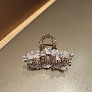 Détail d'une pince à cheveux en cristal avec perles roses sur base gris foncé