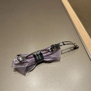 Detailed back view of a purple chiffon bow hair claw with a handmade label and silver clip