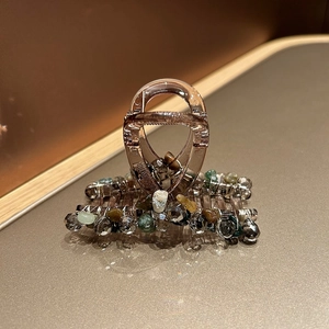 Détail d'une pince à cheveux faite main avec cristaux bruts colorés et fils métalliques