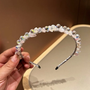 Detailed close-up of handmade pink crystal beads and rhinestones on a silk padded headband