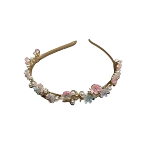 Elegant gold metal headband with pastel resin flowers and white pearls on white background