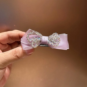 Detailed close-up of lavender crystal bow hair claw clip with shimmering rhinestones