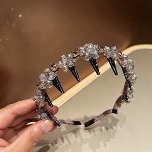 Detailed macro view of purple woven headband featuring handmade crystal flower beads and inner comb