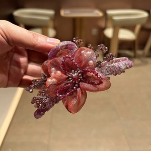 Dettaglio molletta per capelli a fiore in organza con cristalli e perle fatte a mano