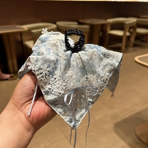 Détail de la pince à cheveux à fleurs bleues avec dentelle et pendentif en cristal