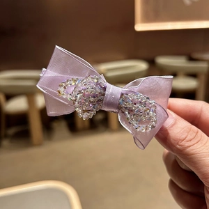 Detail of light purple silk bow hair claw clip with crystal stone embellishments