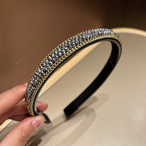Detailed close-up of handmade gray crystal beads and gold chain edges on headband