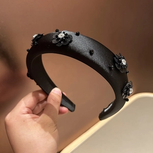 Detailed view of handmade black sequin flower with clear rhinestones on sponge headband