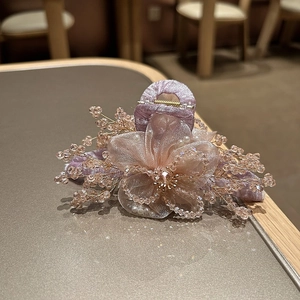 Dettaglio del fermaglio per capelli a fiore in organza con perle e cristalli rosa