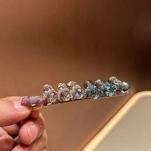 Detail of luxury crystal duckbill hair clip with sparkling gradient beads in gold finish