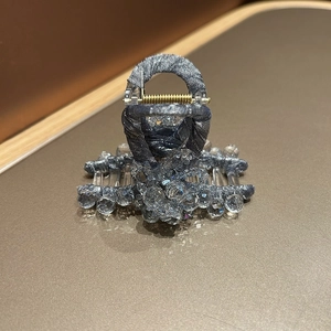 Détail de la pince à cheveux en tissu bleu-gris avec des perles de cristal transparent