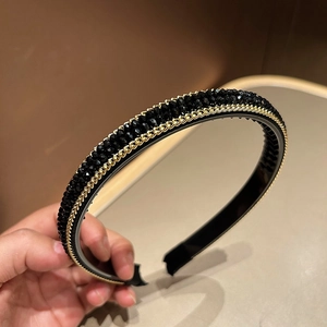 Detail of beaded black headband featuring gold chain edges and anti-slip teeth grip