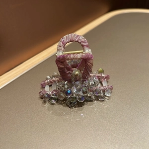 Vue détaillée d'une pince à cheveux en soie violette avec perles de cristal brillantes