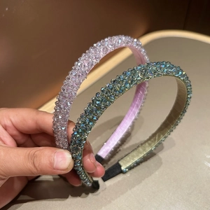 Close-up of handmade crystal beaded headbands in lilac and iridescent green colors