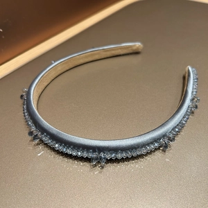 Detailed view of gray satin headband with elegant crystal beads and soft lighting