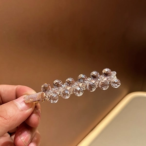 Close-up of luxury hair clip with champagne satin fabric and sparkling crystal beads