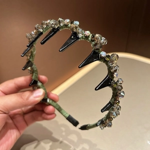 Détail du serre-tête en tissu vert avec cristaux étincelants et dents antidérapantes