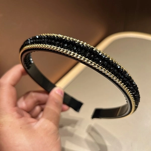 Detail view of handmade crystal beads and gold metal chains on a luxury wide headband