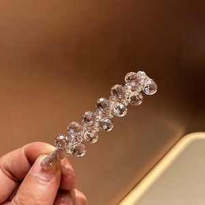 Detailed view of luxury crystal beaded hair clip with light brown satin wrapped base
