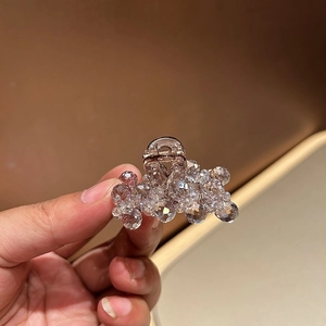Detailed view of luxury gold hair claw clip with sparkling champagne crystals