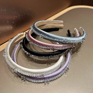 Close-up of five crystal-beaded headbands in assorted colors with satin textures
