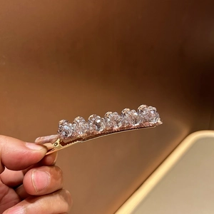 Detail of Korean luxury hair clip with seven sparkling crystal beads on rose gold metal base