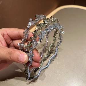 Close-up of wavy crystal headbands in lavender, green, and champagne with sparkling beads