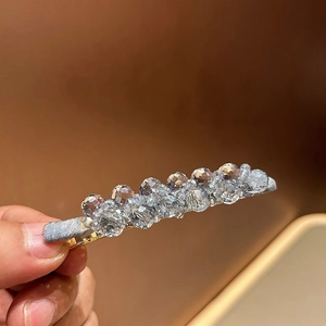 Close-up of luxury sparkling crystal hair clip with grey faceted beads on metal base