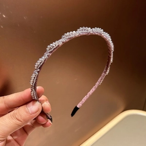 Detailaufnahme des rosa Kristallperlen-Haarreifens mit handgefertigtem Design und Polsterung