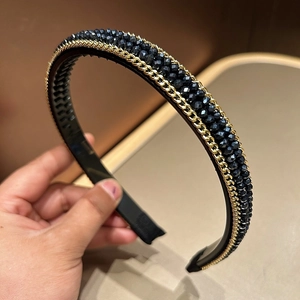 Detailed close-up showing blue crystal beads and gold metal chain weave on the headband