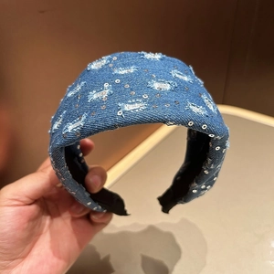 Detail view of vintage denim headband with silver sequins and distressed fringe texture