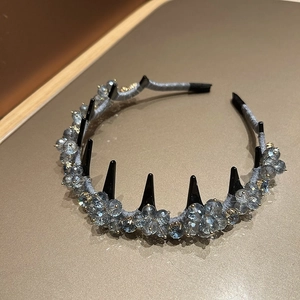 Close-up of luxury grey-blue crystal headband with edgy black spike accents and fabric wrap