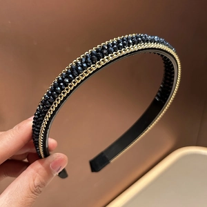 Close-up of handmade beaded headband with faceted black crystals and gold chain details