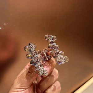Detail of rose gold mini hair claw with iridescent AB crystal beads and metal base