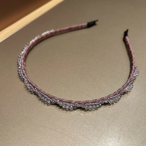 Detail eines rosa Satin-Haarreifs mit handgewebten Kristallen und Silberperlen