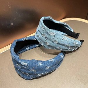Close-up detail of denim headband with sequin accents and fringed edges texture