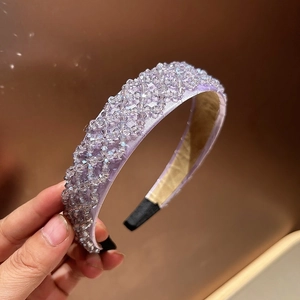 Detailed view of hand-woven purple crystal beads on a wide fabric headband