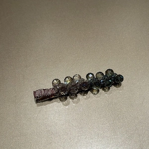 Detailed view of dark grey faceted crystal beads and velvet wrap on a luxury hair clip