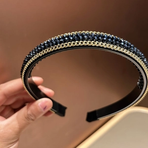 Detail of beaded fashion headband featuring blue crystals and golden chain trim