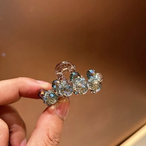 Detail view of mini crystal hair claw clip with iridescent faceted beads for elegant styling