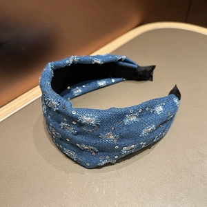 Close-up of retro denim headband with silver sequins and distressed fraying details