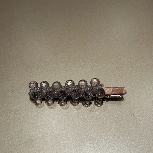 Close-up of grey faceted crystal beads and premium metal duckbill clip for hair