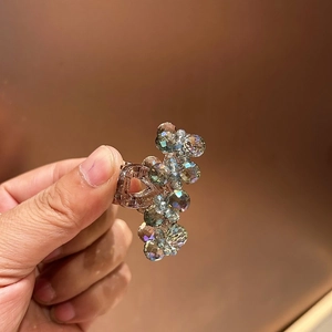 Close-up of luxury mini crystal claw clip in rose gold alloy with iridescent beads