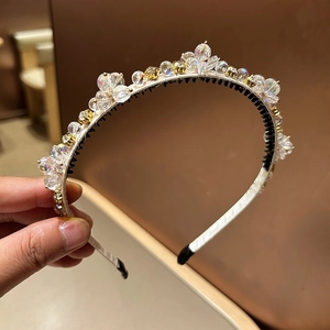 Détail d'un serre-tête élégant orné de perles de cristal et de petites perles dorées